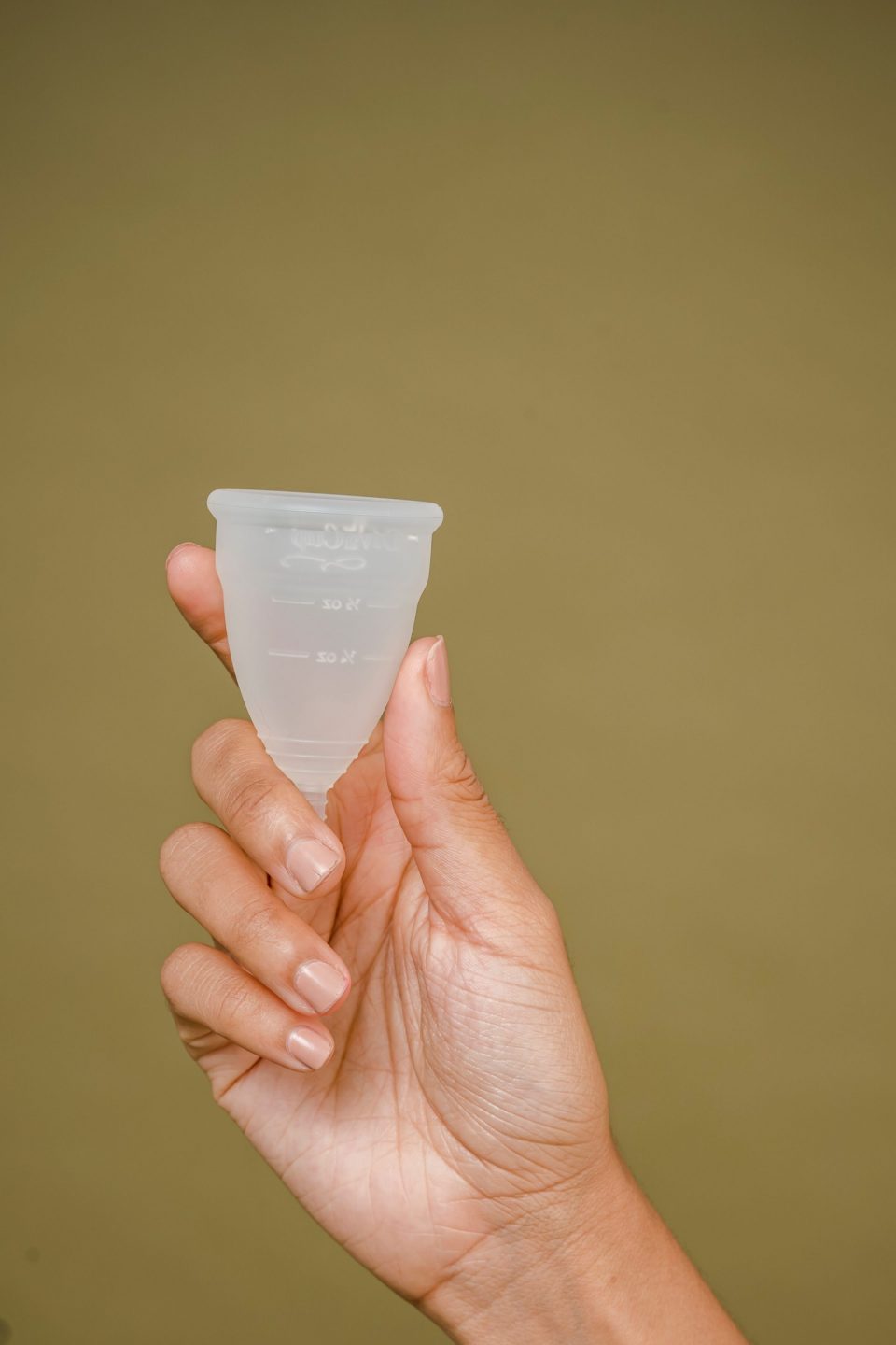 Person holding a clear menstrual cup