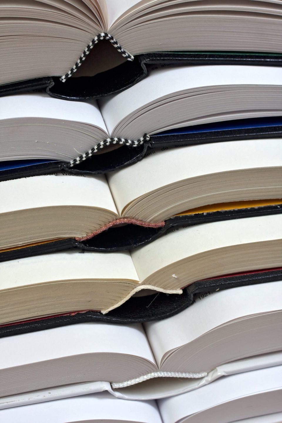 Several thick hardcover books stacked on top of each other