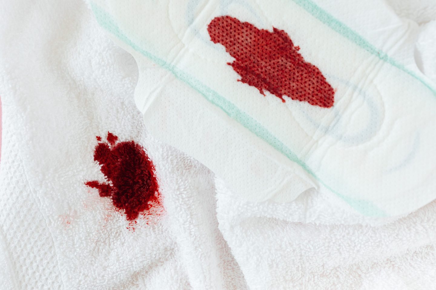 Menstrual blood on a white towel and menstrual pad
