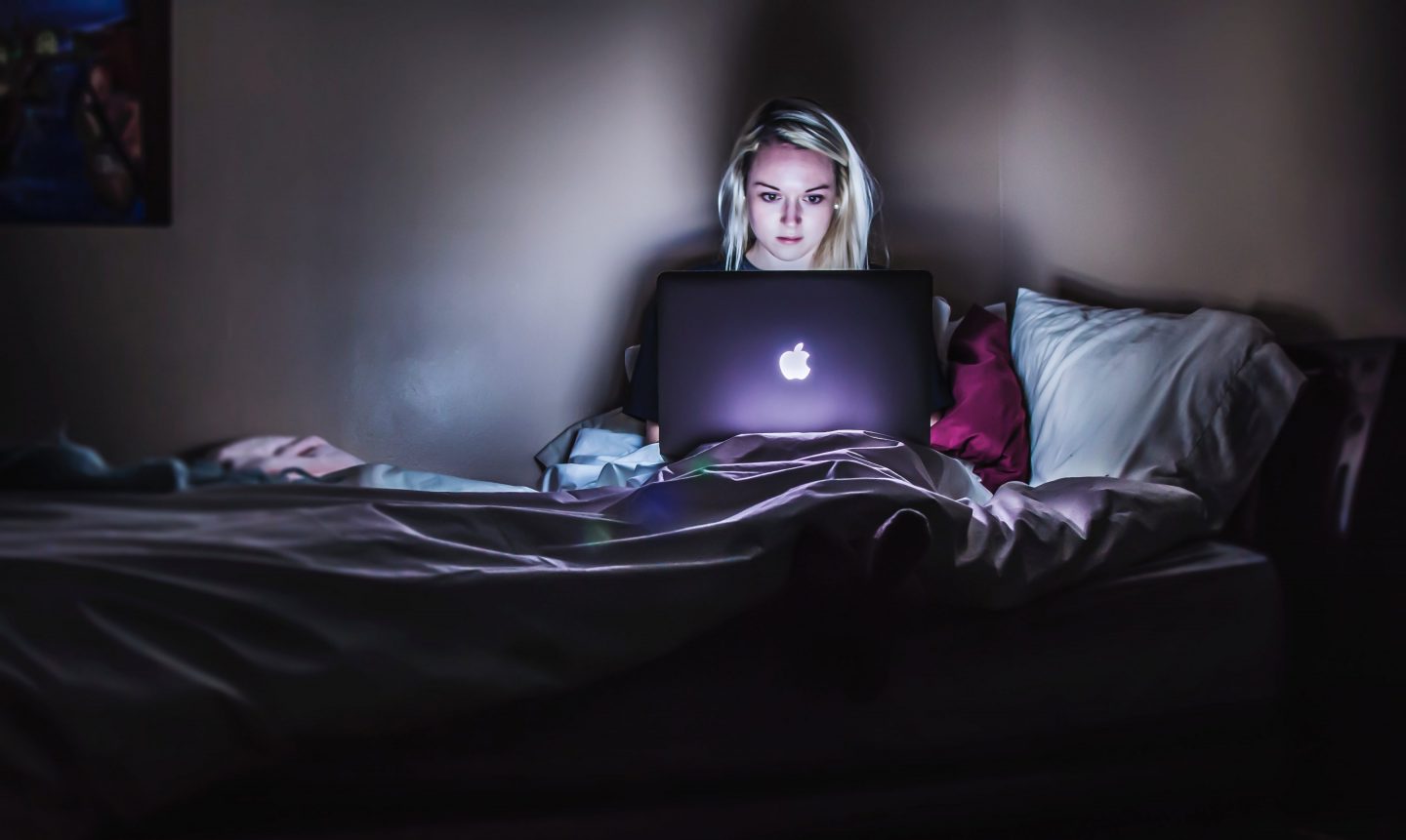 Concerned woman sitting in the dark on her computer