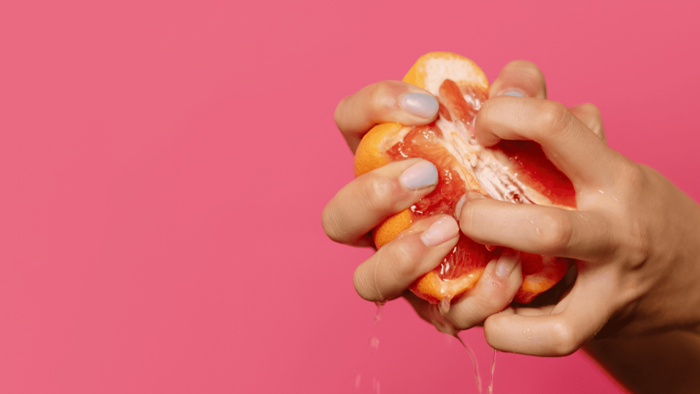 Hands squeezing a grapefruit